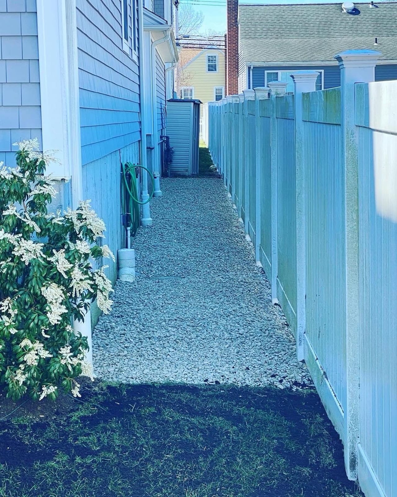 Gravel walkway and drainage area beside a Fairfield County home