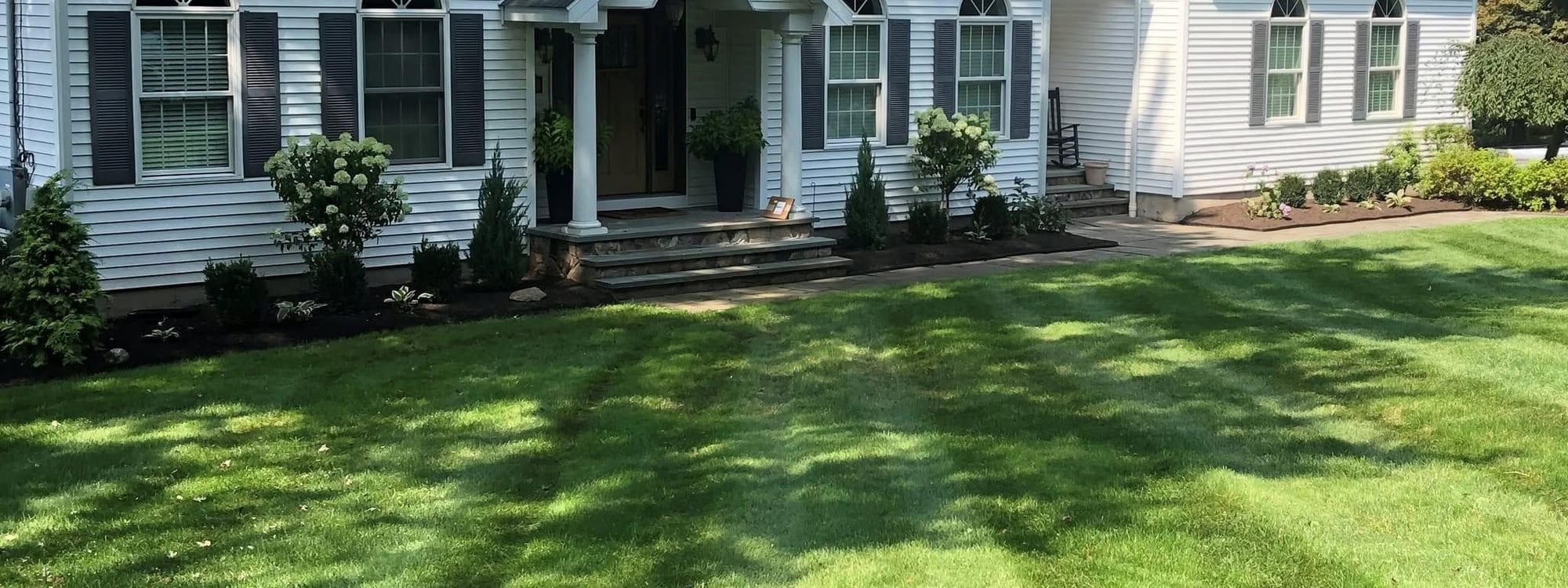 Fairfield County landscaping with a maintained lawn and foundation plantings by Bollinger Landscaping